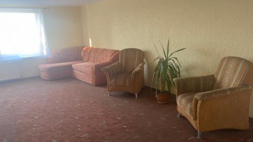 a living room with two chairs and a couch at Paradize in Daugavpils