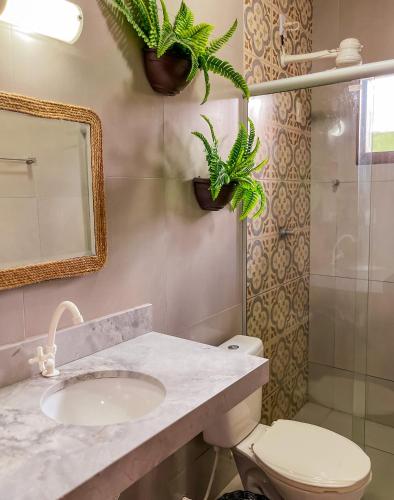 a bathroom with a sink and a toilet and plants at Kadosh Pipa Hospedagem in Pipa