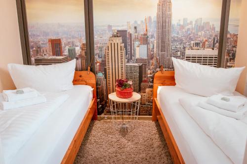 two beds in a room with a view of a city at Ferienwohnung Marth in Sankt Andreasberg