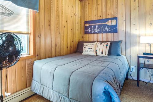 a bedroom with a bed with a fan and a window at Lakefront Marenisco Cabin with Private Dock! in Bergland