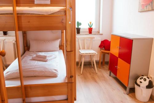 1 Schlafzimmer mit 2 Etagenbetten und einem Schreibtisch in der Unterkunft Ferienwohnung Bergidylle in Sankt Andreasberg
