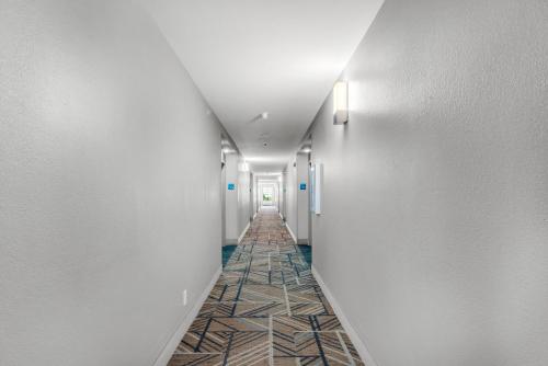 a hallway with white walls and a tile floor at Holiday Inn Express Destin E - Commons Mall Area by IHG in Destin