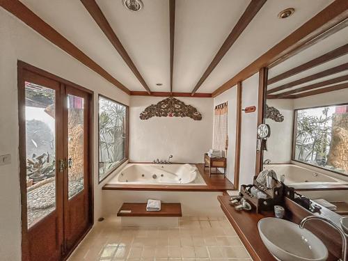 a large bathroom with a tub and a sink at Karinthip Village in Chiang Mai