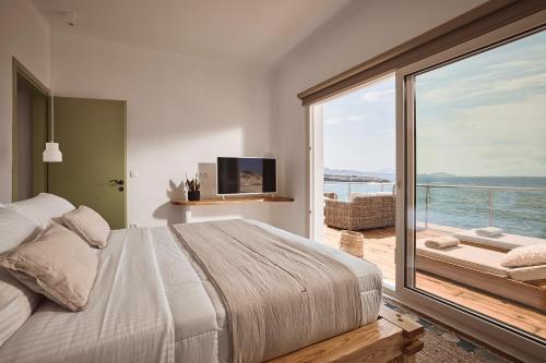 a bedroom with a large bed and a large window at Infinity Villa milos in Pachaina