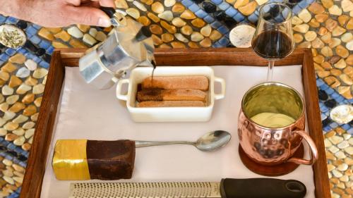 a tray of food with a spoon and a glass of wine at The Villa Casa Casuarina in Miami Beach