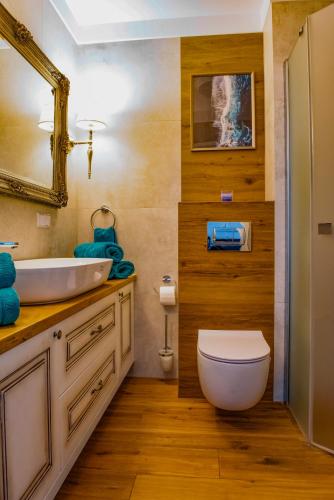 a bathroom with a white toilet and a sink at Apartament Mandala Grzybowo in Grzybowo