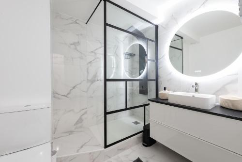 une salle de bain blanche avec un miroir et un lavabo dans l'établissement Appartement moderne à 2 pas de la Gare, à Toulouse