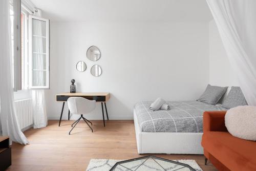 um quarto branco com uma cama e uma secretária em Appartement moderne à 2 pas de la Gare em Toulouse