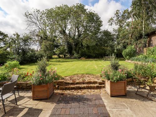 a garden with three wooden containers with flowers in it at The Waggon Shed in Nottingham