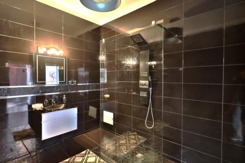 La salle de bains noire est pourvue d'une douche et d'un lavabo. dans l'établissement Riad 5 Chambres & Piscine & Breakfast - Marrakech, à Marrakech