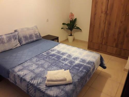 um quarto com uma cama com um edredão azul em tilis מרגולין 33 תל אביב em Tel Aviv