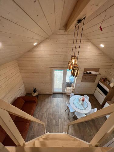 a room with a table in a wooden house at Milkės Karibai - poilsio namelis su sauna ir kubilu in Statiškė