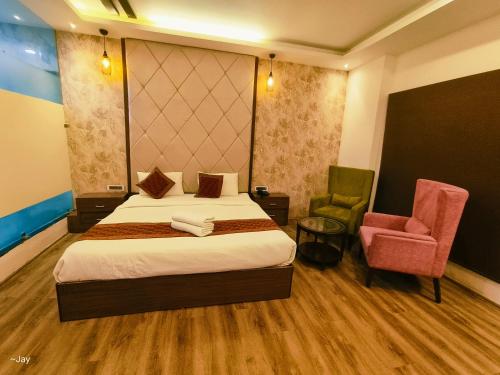 a hotel room with a bed and a chair at Trimrooms Triumph Banaras Railway Station in Varanasi
