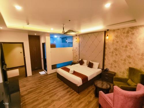 a bedroom with a bed and a couch and a chair at Trimrooms Triumph Banaras Railway Station in Varanasi