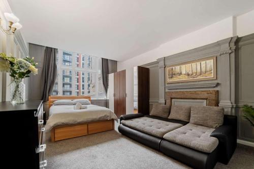 Spacious City Centre Apartment w/ Free Valet Parking في ليستر: غرفة نوم بسرير واريكة