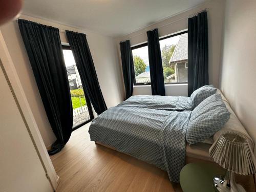una camera con un letto e due grandi finestre di Skagesund guest house with free parking a Tromsø