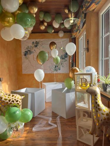 a room with balloons and a table with a giraffe at Hotel Forsthaus in Volkesfeld