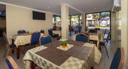 a restaurant with tables and chairs and a television at Hotel Sada in Guayaquil