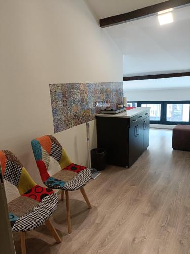 a living room with chairs and a counter and a kitchen at UB Prenociste in Vranjska Banja