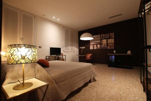 a bedroom with a bed and a lamp on a table at Le Maginot Relais in Castelvetro Piacentino