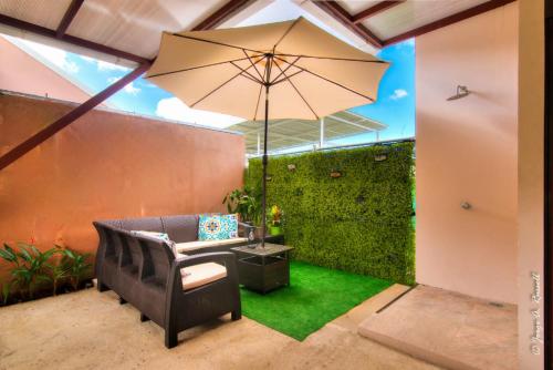 patio z krzesłem, parasolem i trawą w obiekcie Natural Arenas 47 ! w mieście Herradura