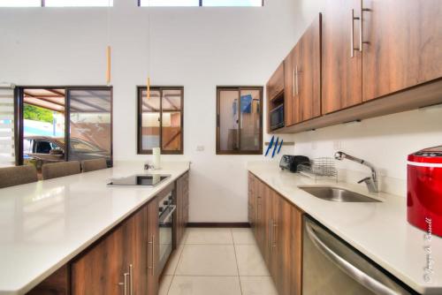 a kitchen with white countertops and wooden cabinets at Natural Arenas 47 ! in Herradura