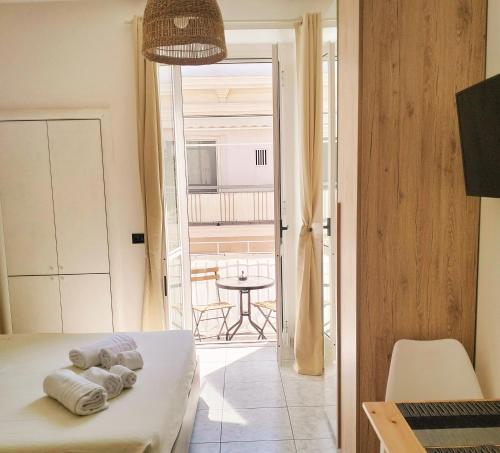 a bedroom with a bed and a table and a balcony at Petracca Guest House in Monopoli