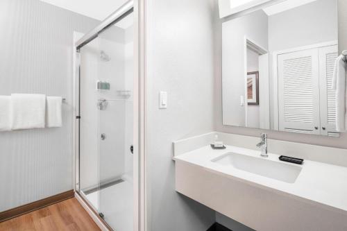 斯科茨代爾的住宿－北斯科特斯德萬怡酒店，白色的浴室设有水槽和淋浴。
