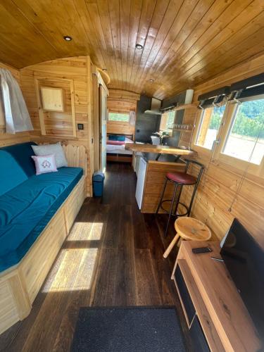 Alpine love shack في Villar-Saint-Pancrace: غرفة بها سرير ومطبخ في عربة سكن متنقلة