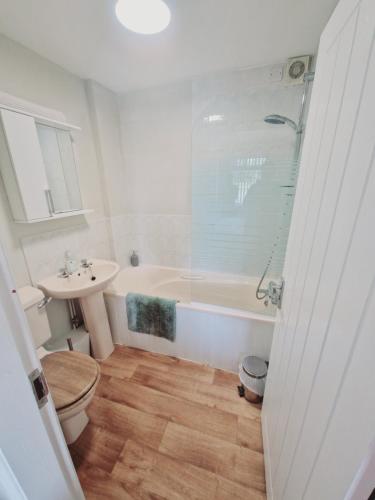 a bathroom with a tub and a toilet and a sink at The Bosville Arms in Rudston