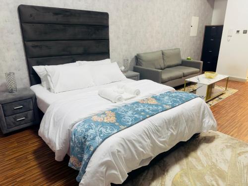 a bedroom with a large bed and a chair at Cozy Apartment in Jumeirah Village Circle, Dubai. in Dubai