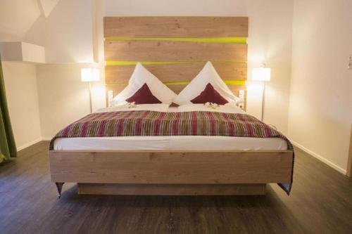 a bedroom with a large bed with two lamps at Gasthaus Schwarzer Adler in Colmberg