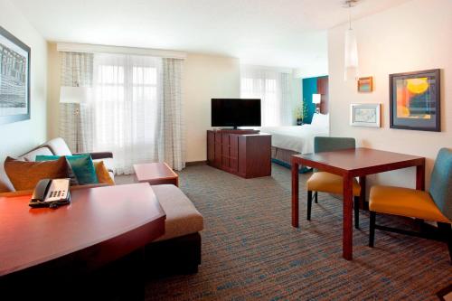 a hotel room with a living room with a bed at Residence Inn by Marriott Portland Airport at Cascade Station in Portland