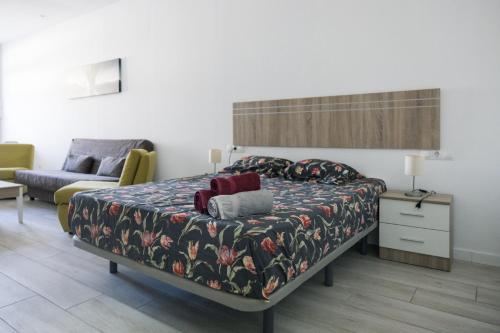 sypialnia z łóżkiem i kanapą w obiekcie Apartamento VELARDE CENTER one w Maladze