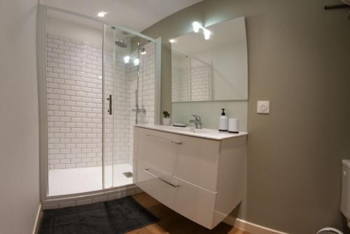 een witte badkamer met een douche en een wastafel bij Sweet Room AP - 3mn de la Gare in Agen