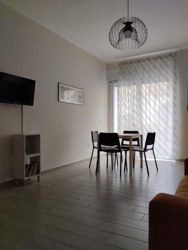 Una sala de estar con mesa de comedor y sillas. en Appartamento via Roma, en Recale