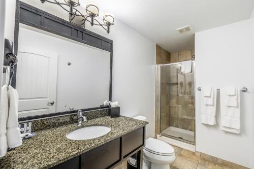 a bathroom with a sink and a toilet and a mirror at The Ridge Hotel in Lake Geneva