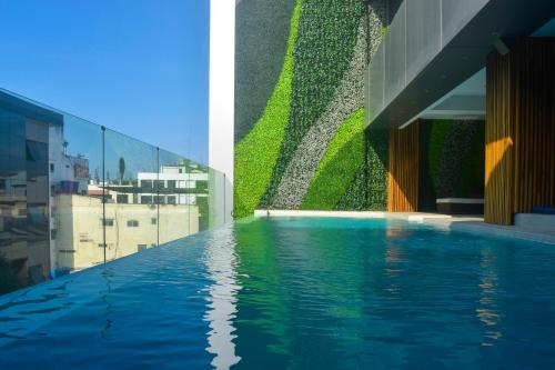 a swimming pool on the side of a building at Hotel Veuxor in Machala