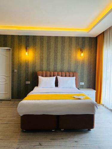 a bedroom with a large bed with orange curtains at deperlas in Atakum