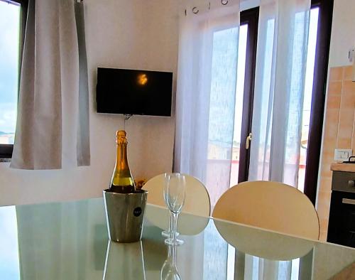 Una botella de champán sentada en una mesa de cristal con dos sillas en Maison Du Port - Palau, en Palau