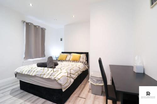 una camera con letto, tavolo e scrivania di Den Accommodation & Short Lets Greenwich London - 3 Bed House a Londra