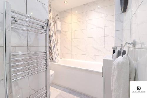 a bathroom with a shower and a tub and a toilet at Den Accommodation & Short Lets Greenwich London - 3 Bed House in London