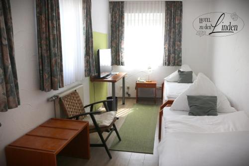 una habitación de hotel con 2 camas y una silla en Hotel zu den Linden en Wachtberg