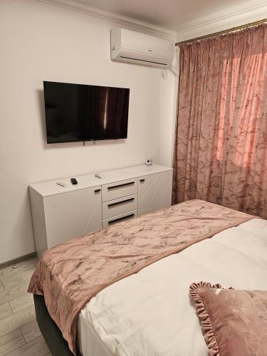 een slaapkamer met een bed en een flatscreen-tv bij APARTAMENT 9 RO&MARIO Barlad in Bîrlad