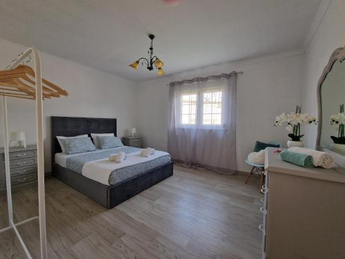 1 dormitorio con cama, tocador y espejo en Villa Monte Branco, en São Bartolomeu de Messines