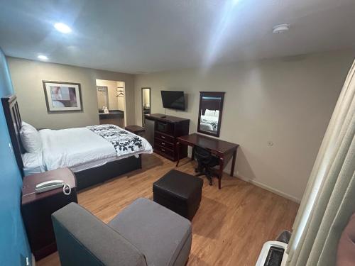 1 dormitorio con cama, escritorio y silla en Blue Star inn en Lafayette