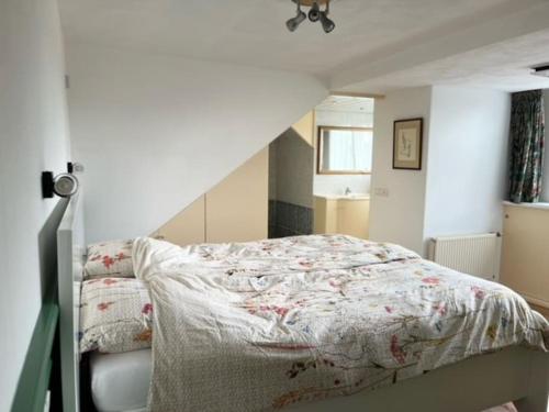 a bedroom with a bed with a floral comforter at Huisje Marie Loosdrecht in Loosdrecht