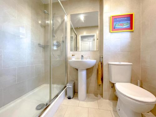 a bathroom with a toilet and a sink and a shower at Escape to Tranquil 1 bed, Poole in Canford Magna