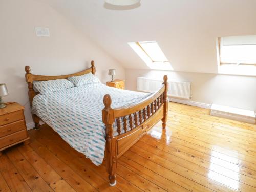 a bedroom with a bed and a wooden floor at Aisling in Foxford