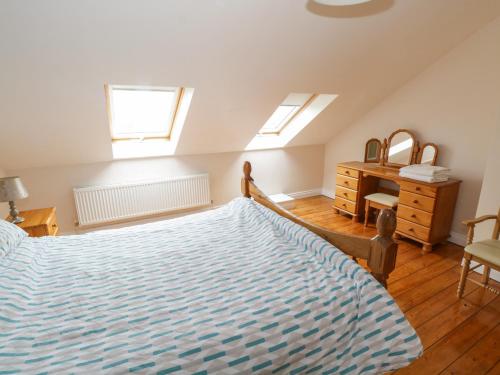 a bedroom with a bed and a dresser and two windows at Aisling in Foxford